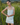 Woman standing in front of a field with long grass, wearing a pointelle tank top and white denim skirt.