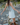 Woman walking on a rocky path wearing a white dress and brown boots.