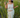 Woman in a white outfit standing in tall grass.
