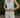 Person wearing a white sleeveless top and beige shorts outdoors.