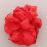 Red flower-like fabric item on a light gray background