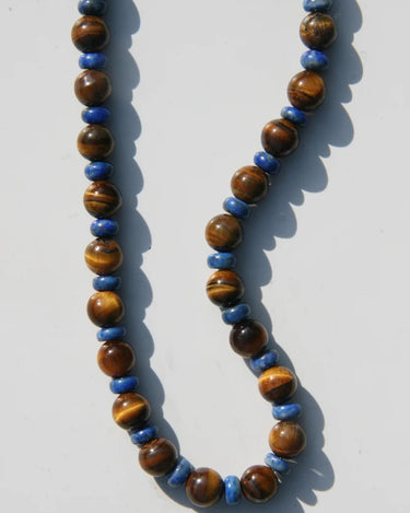 Necklace with brown and blue beads on a white background