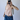 Person wearing a red-striped halter top and blue jeans, taking a mirror selfie.