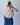 Person wearing a red-striped halter top and blue jeans, taking a mirror selfie.