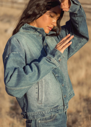Woman wearing a denim jacket in a desert setting