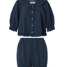 Navy blue eyelet, button-up blouse with a ruffled neckline and matching bloomer-style shorts set on a white background.