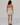 Woman wearing a beige tank top and bloomer short set against a white background