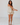 Woman wearing a beige tank top and bloomer short set against a white background