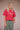 Person wearing a red t-shirt with graphic design on a plain background