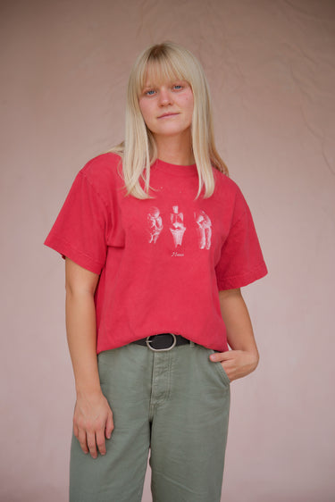Person wearing a red t-shirt with graphic design on a plain background