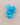 A bright turquoise blue fabric flower brooch with a gold-tone safety pin clasp, displayed on a neutral beige background.