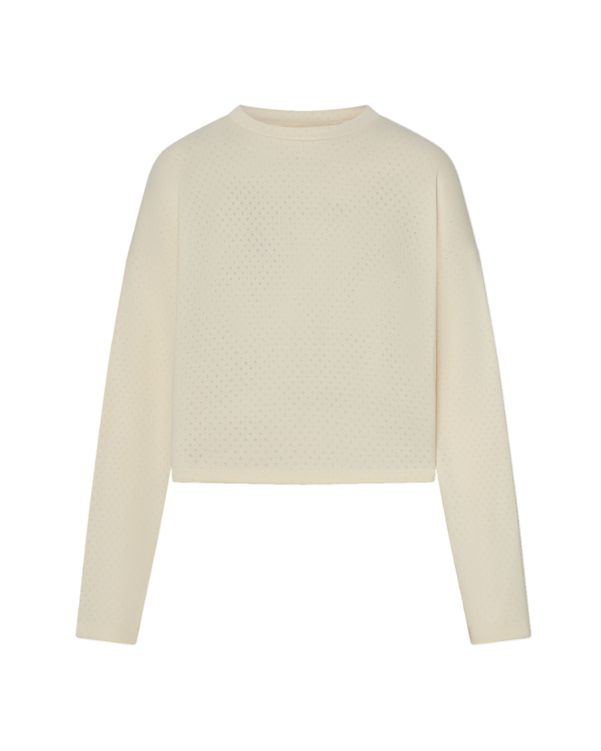 Cream long sleeve top with pointelle details on a white background.