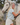 Woman hugging a white horse in a natural setting