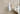 Hand holding a white handheld steamer against a beige background