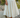 Person wearing a cream skirt standing on rocks with a natural background