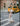 Woman in a polka dot dress crossing a street with a yellow taxi in the background.